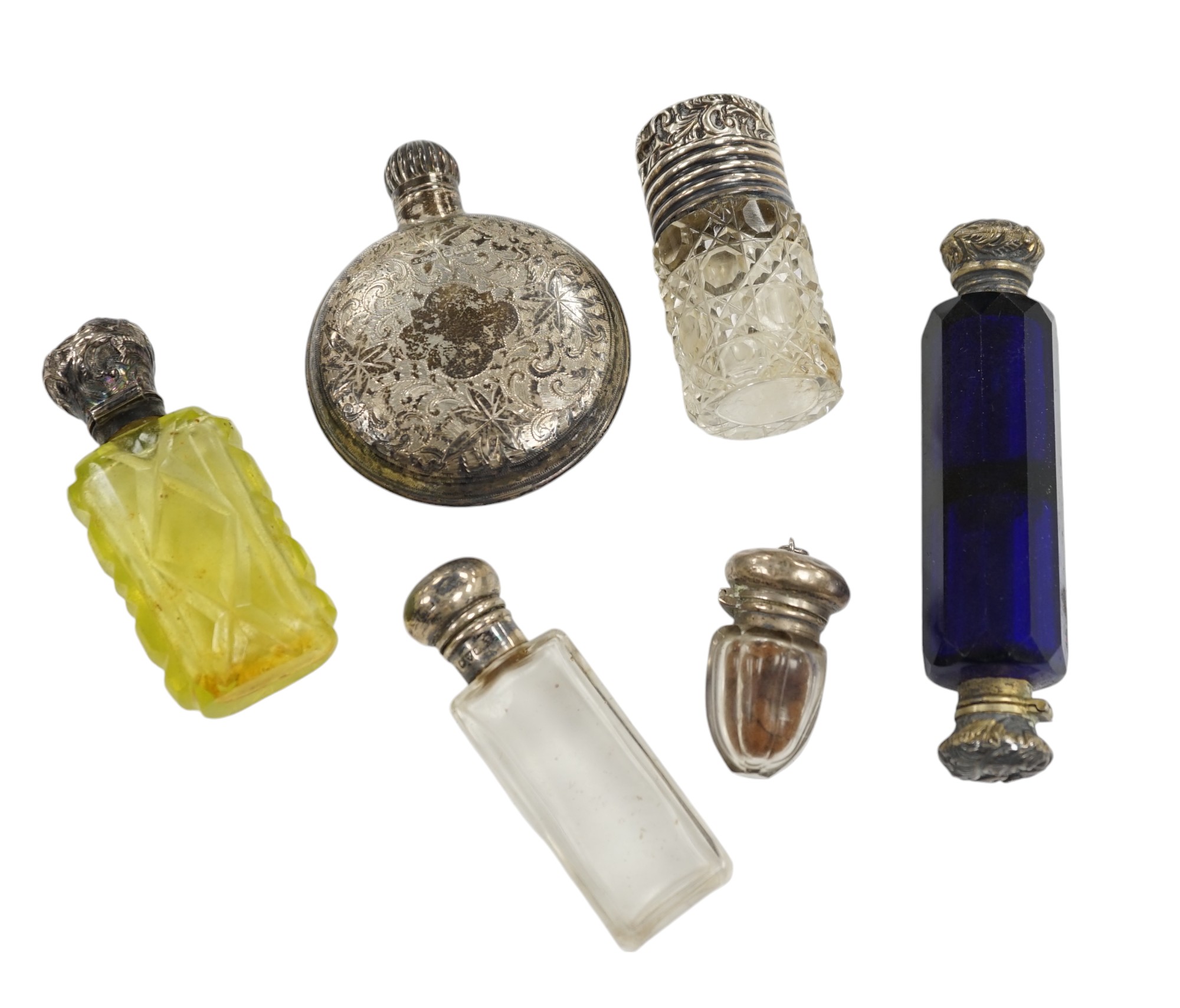 A George V engraved silver moon shaped scent bottle, James Dixon & Sons, Sheffield, 1912, together with five other white metal mounted glass scent bottles. Condition - poor to fair